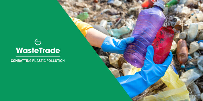 戴着手套的手拿着一个脏兮兮的塑料瓶，上面覆盖着 "WasteTrade Combating Plastic Pollution "的文字。